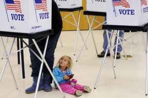 Child sits quietly as parent votes - Courtesy USAToday